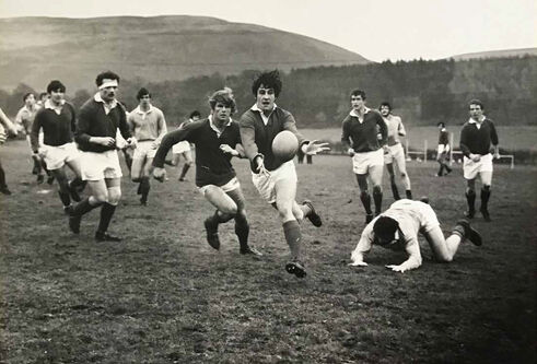Black and white photo of students playing rugby