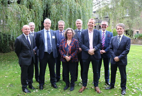 Attendees of the launch of the Dundee Dental Hospital and Research School gather in a garden space. Professor Jan Clarkson stands in the middle 