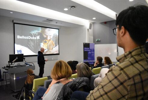 Lecture theatre showing a large screen with Bella&Duke as the heading