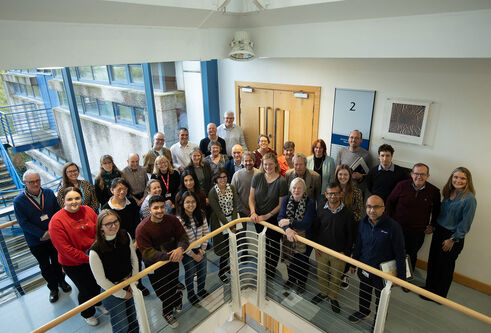 The Parkinson's research team standing at a balcony in the School if Life Sciences building.