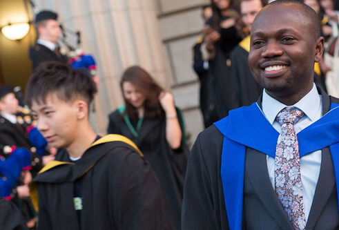 Student outside Caird Hall at Winter Graduation