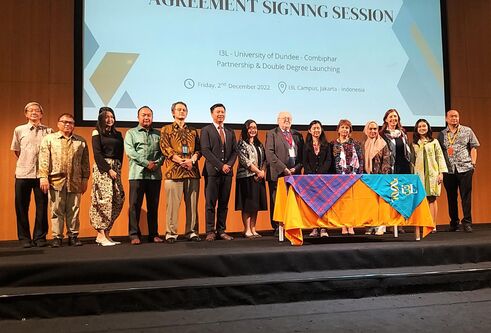 A group stood on stage in front of presentations slides