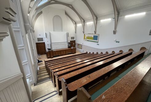 Carnelley Large Lecture Theatre a view from the top of the theatre showing rows of wooden benches and ornate ceiling