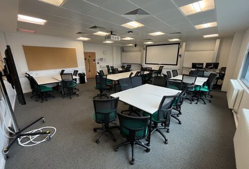 Dalhousie 1G06  - several white tables set in squares with black chairs spread out across the room