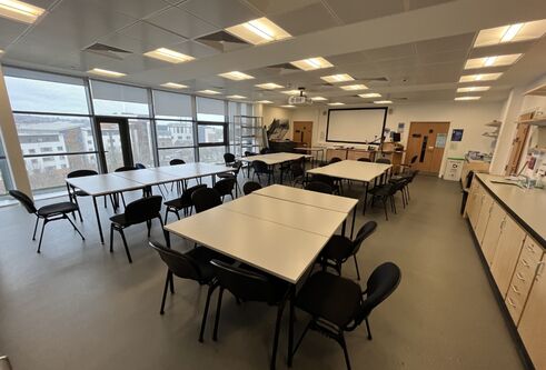 Dalhousie 1S03  - several tables set in squares with chairs and a white screen on the wall