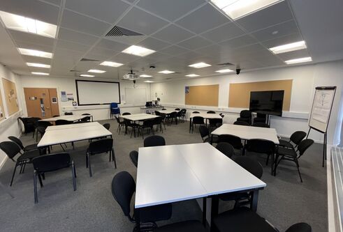 Dalhousie 2F14 - several tables set in squares with chairs and a tv mobile screen and white screen on the wall