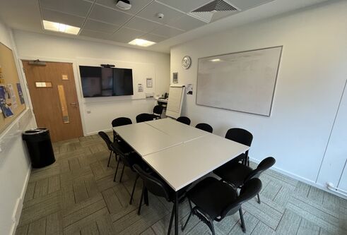 Dalhousie 2S01 - one table set up in an oblong shape with chairs. A white board and tv screen on the wall