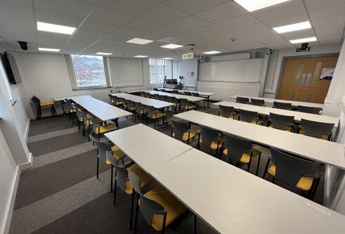 Fulton room showing white tables and a large white screen