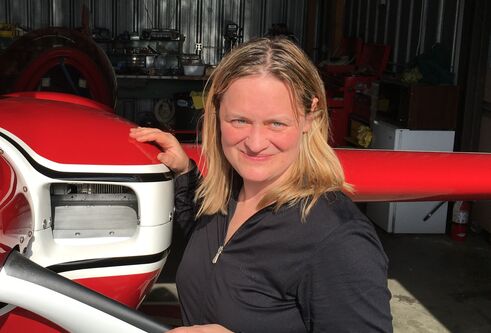 Pic of Prof Iris Grunwald standing next to an airplane