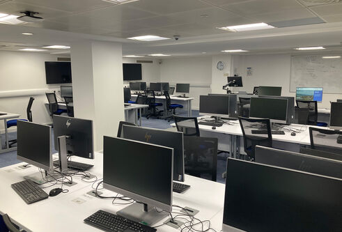 IT  Suite in the Tower Basement showing several rows of computer screens on white desks 