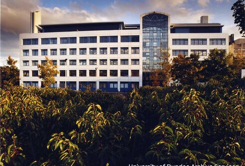 The Wellcome Trust building, with bushes in the foreground.