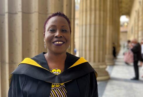 Ify Tony-Monye dressed in graduation robes outside Caird Hall