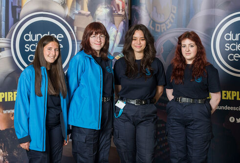 Four students standing in front of a Dundee Science Centre banner