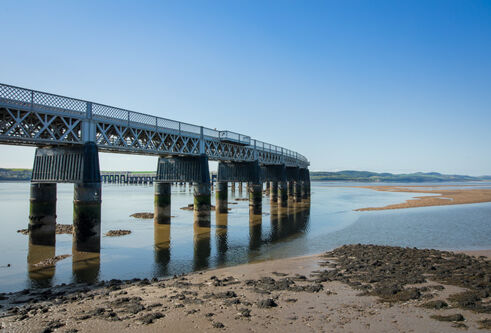 rail bridge stretching out across the river on a sunny day