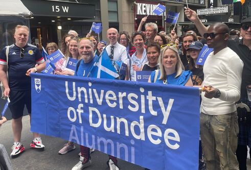 Alumini team holding banner of University of Dundee 