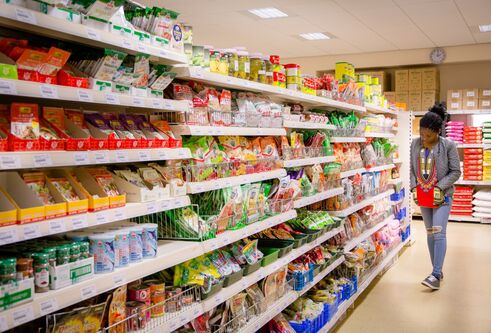 student looking along supermarket shelves