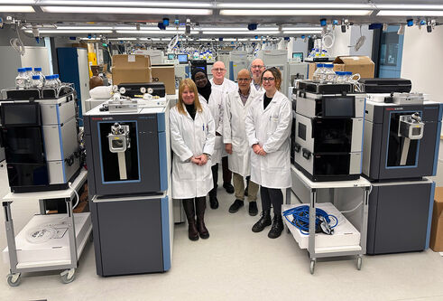 Fingerprints Proteomics Facility team standing next to the two novel Orbitrap Astral Mass Spectrometers, which are now partially assembled.