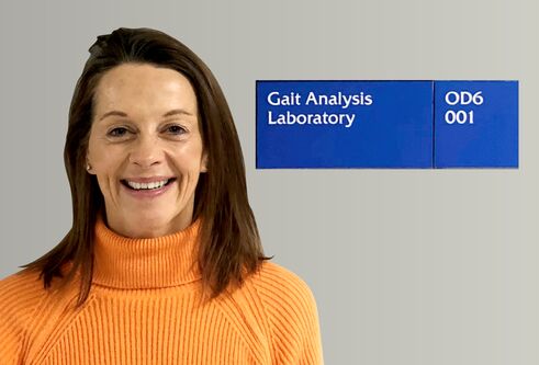 Jane Grant in front of lab sign