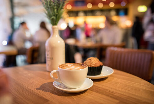 Cup of coffee and a cake on a table in a cafe