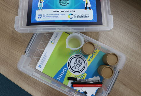 Photo of the forensic chemistry at home kit featuring the booklet and materials that come with the kit