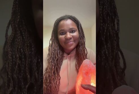 Tendayi sitting holding a crystal lamps