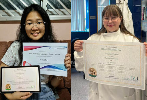 Two people smiling holding certificates