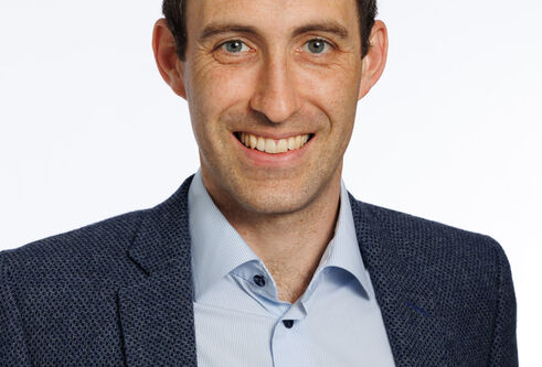 A portrait shot of Dr Mark Baxter infront of a white background