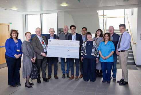 Group photo of Clinical Research Centre staff and Trustees holding a cheque for £50,000