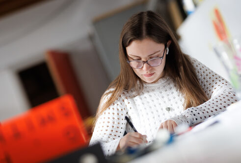 A student writing in a studio environment