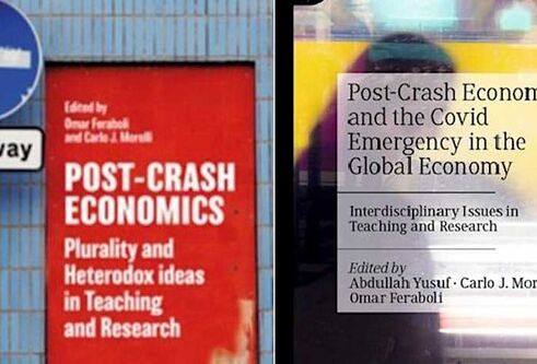 A blue sign with a white arrow pointing left, a red poster is in the middle with white writing and text to the side says "post crash economics and the covid emergency in the global economy".
