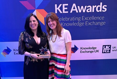 Professor Ross and Dr Armstrong with their award standing in front of an awards backdrop