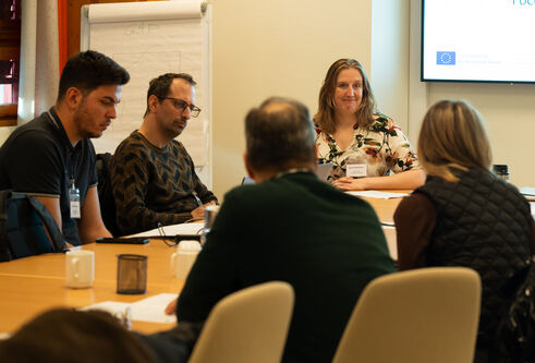 Members of the Clarus project sitting at a table facing each other during a meeting in Oslo, Norway