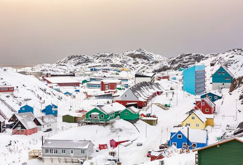 An image of homes on Greenland surrounded by snow