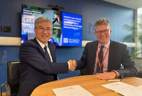 Professor Rory McCrimmon (right) shaking hands with the Dean of the Chinese delegation