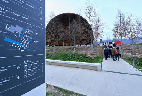 The exterior of the CERN complex in Geneva, Switzerland, showing a tall, wood-clad spherical building