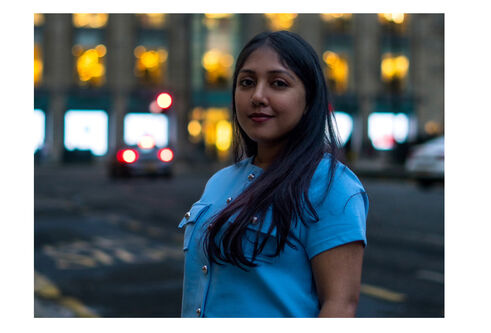 Sherin standing on the side of a road with an office building in the background
