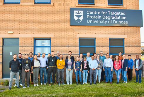 A large group photo of members of the CeTPD standing outside of the building