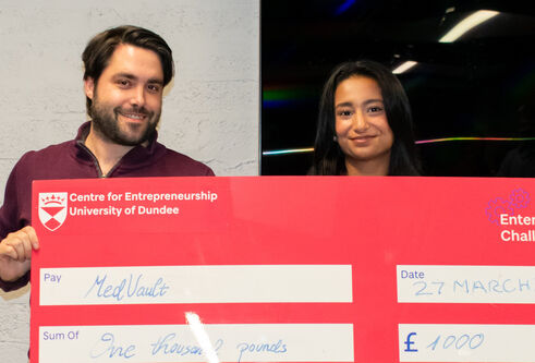 Chris Smyth standing with Amna Waqas of MedVault, winner of the Enterprise Challenge final, holds up a large check