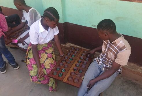 African street children sitting and playing a game
