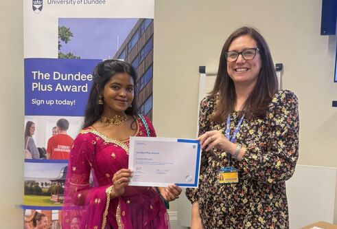 two women holding a certificate