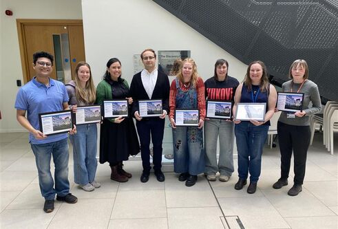 people stood together smiling holding award certificates