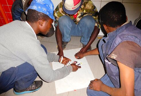 African street children sitting and playing a game