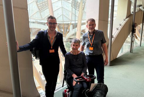 Dr Tom Griffiths, Professor Annalu Waller and Rohan Slaughter stand next to one another in a corridor
