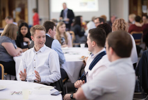 Students sitting discussing ideas at a table as part of an event