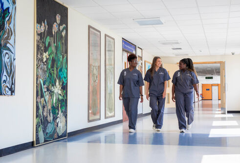 Dundee medical students with scrubs on walking in corridor at Ninewells hospital