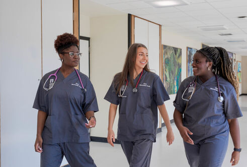 Three medical students wearing scrubs at the University of Dundee School of Medicine