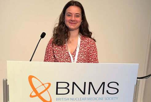 Abby Lang standing at a podium with a BNMS banner posted at the front of the podium