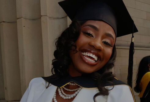 : A close image of a student wearing a white top, with beaded necklace and graduation cap on her head