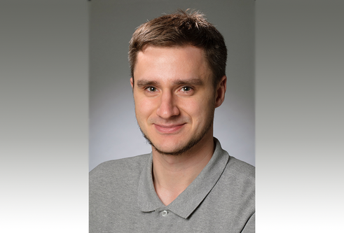 A head and shoulders photo of a man smiling