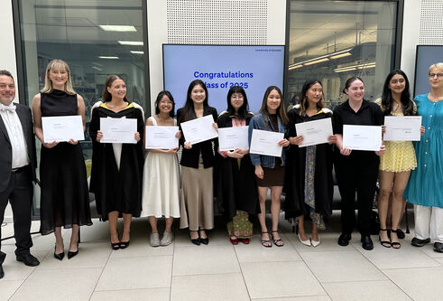 A group of people smiling with their prize certificates